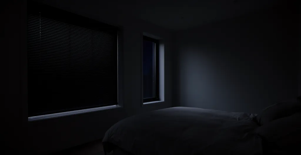 Chambre plongée dans une obscurité totale grâce à des volets occultants pour un sommeil réparateur
