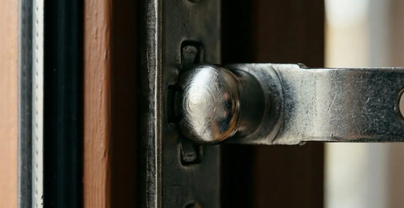 Vue macro d'un galet de fermeture champignon sur fenêtre moderne avec mécanisme de verrouillage visible